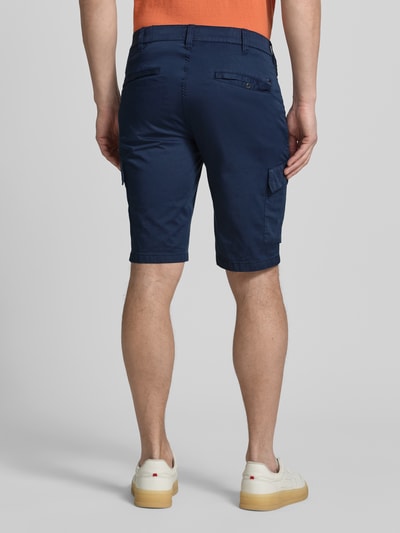 Männermodel trägt Regular Fit Cargoshorts aus Baumwoll-Mix von Brax in Dunkelblau mit Cargotaschen, unifarben, Ganzkörperansicht Rückansicht.