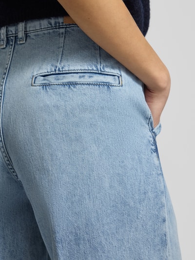 Frauenmodel trägt Wide Leg Jeans Modell 'Emanuela' von JOOP!, helle Reine Baumwolle, Gelegte Falten, Gesäßtaschen, Detailaufnahme.