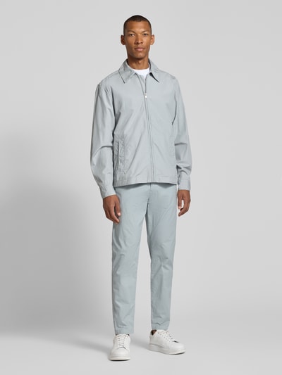 Mannelijk model draagt lichtgrijze tapered fit chino uit katoenmix model 'GABARDINE' van BOSS Orange, volledige lichaamsvooraanzicht.