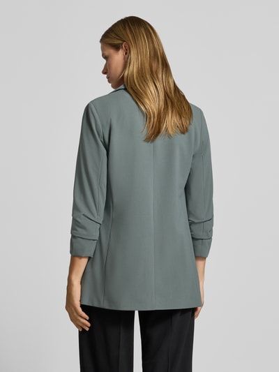 Frauenmodel trägt Regular Fit Longblazer mit 3/4-Arm Modell 'KALINA' von ONLY in gedämpftem Grün, glatte Textur, Ganzkörperansicht Rückansicht, Damen Longblazer von ONLY.