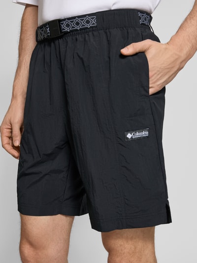 Männermodel trägt schwarze Shorts mit Gürtel Modell 'Sequoia Grove™' von Columbia, lockerer Schnitt, Nahaufnahme Oberschenkel.