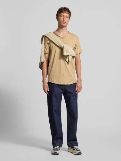 Männermodel trägt Regular Fit T-Shirt aus reiner Baumwolle Modell 'BENNE LONGY' von Only & Sons in Beige, V-Ausschnitt, kurzarm, unifarben, Ganzkörperansicht von vorne