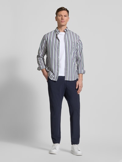 Männermodel trägt Slim Fit Hose mit Paspeltaschen am Gesäß von CRUNA, dunkelblau, Material-Mix mit Stretch-Anteil, Eingrifftaschen, Ganzkörperansicht von vorne.