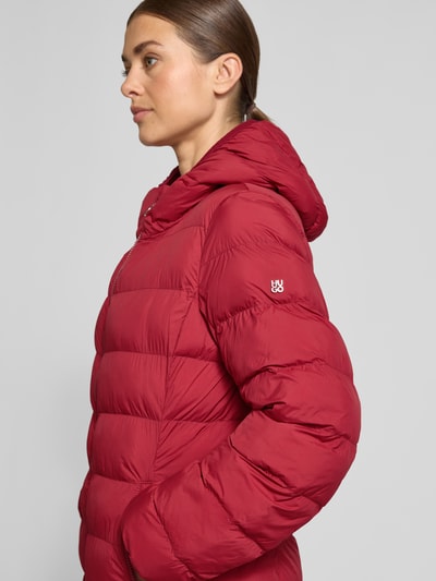 Frauenmodel trägt Regular Fit Steppmantel mit Kapuze Modell 'Famalia-4' von HUGO, unifarben, matt, sichtbare Taschen und Nähte, Nahaufnahme Oberkörper.