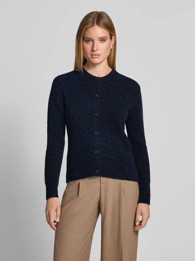 Modelka kobieca ma na sobie Regular Fit Cardigan aus Woll-Alpaka-Mix Modell 'NOR' od Samsøe Samsøe, ciemnogranatowy kolor, imitacja dzianiny, długi rękaw, okrągły dekolt, listwa guzikowa, damski kardigan z mieszanki wełny i alpaki, krój regular fit, długość tyłu w rozmiarze S: 59 cm, długość rękawów w rozmiarze S: 62 cm, widok całej sylwetki z przodu.