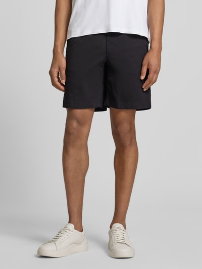 Männermodel trägt Chinoshorts aus Baumwoll-Mix Modell 'DOVER' von Tommy Hilfiger, Optik: Unifarben, Passform: Regular-Fit, Ganzkörperansicht von vorne.