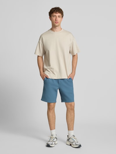 Mannelijk model draagt Shorts met structuurpatroon model 'JAIDEN' van Jack & Jones van puur katoen, regular fit, elastische band met tunnelkoord, bandwijdte maat M 43 cm, binnenbeenlengte 23 cm, blauw, ontspannen pasvorm, voorkant volledig zichtbaar, geheel lichaam vooraanzicht.