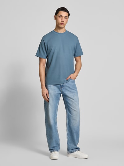 Männermodel trägt Herren T-Shirt mit Rundhalsausschnitt Modell 'AUSTIN' von Jack & Jones, Elastischer-Material-Mix, gerader Schnitt, Ganzkörperansicht von vorne.