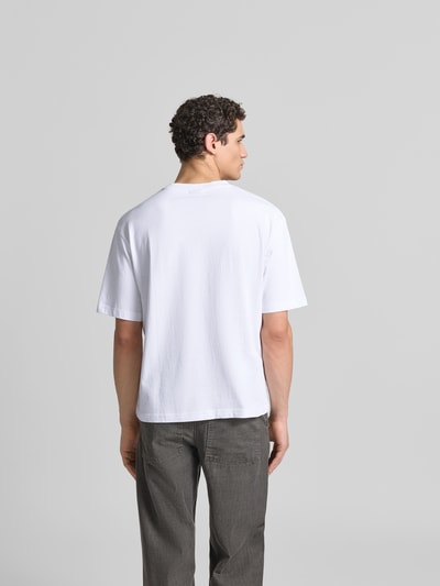Männermodel trägt Relaxed Fit T-Shirt aus reiner Baumwolle von ANNARR, weiß, Label-Print, Kurzärmelig, Rückenlänge 67 cm, Ganzkörperansicht Rückansicht.