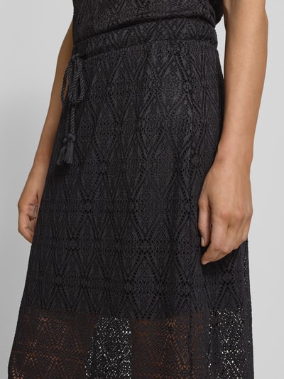 Frauenmodel trägt Leicht ausgestellter Midi-Rock aus Spitze mit elastischem Bund Modell 'MAYA' von Vero Moda, unifarben, transparente Textur, Nahaufnahme Oberkörper.