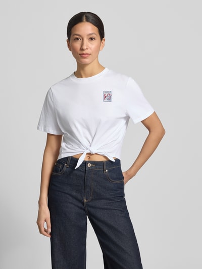 Frauenmodel trägt T-Shirt mit Knotendetail und Rundhalsausschnitt von Rich & Royal, reine Baumwolle, Regular Fit, Weiß, Nahaufnahme Oberkörper.