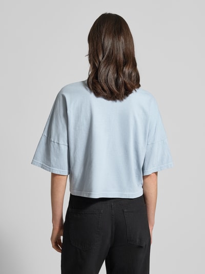 Vrouwenmodel draagt Boxy Fit T-Shirt met verlaagde schouders model 'KUSIA' van Drykorn, puur katoen, ronde hals, ruglengte bij maat S 50 cm, zijaanzicht, volledig lichaam rugaanzicht