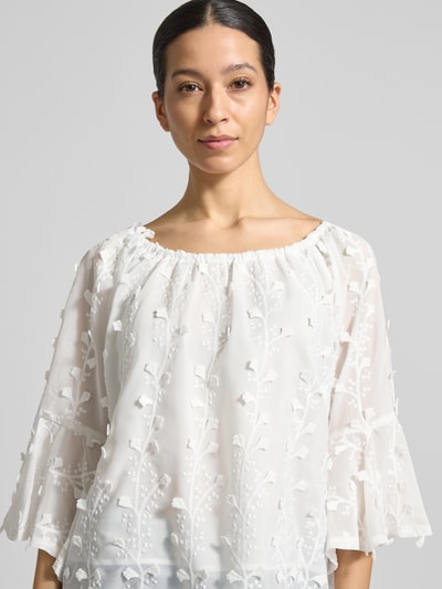 Kobiece model prezentuje Blusenshirt mit Spitze von Apricot, luźny krój, dekolt carmen, koronka, falbany, długość tyłu w rozmiarze S: 51 cm, długość rękawa w rozmiarze S: 42 cm, jasny kolor, krótka faktura, przód górnej części ciała, zbliżenie