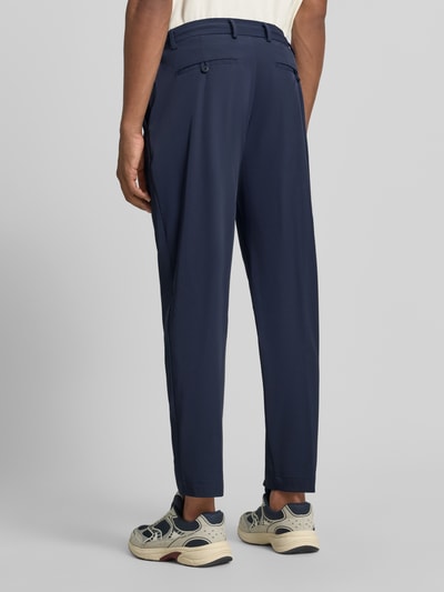 Männermodel trägt dunkelblaue Anzughose mit Bügelfalte Modell 'PANTALACCIO' von MARKUP, glatte Oberfläche, Ganzkörperansicht Rückansicht, Material-Mix mit Stretch-Anteil, Straight Fit, elastischer Bund, Knopf- und Reißverschluss, französische Eingrifftaschen, Gesäßleistentaschen, Bundweite 44 cm, Innenbeinlänge 70 cm.