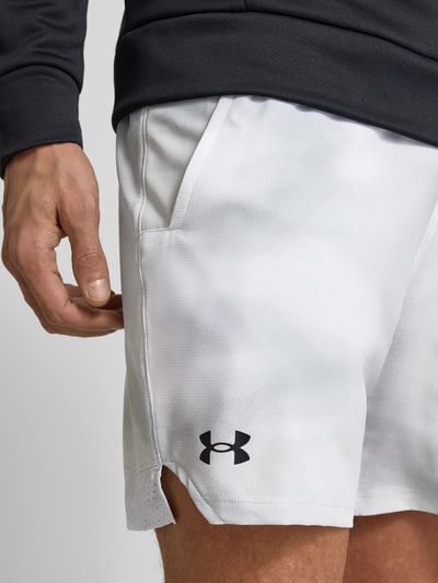 Männermodel trägt Shorts mit elastischem Bund von Under Armour, weiß, Label-Print, Eingrifftaschen, Nahaufnahme Oberschenkel.