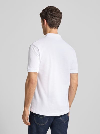 Männermodel trägt Poloshirt mit Label-Stitching Modell 'L.12.12 CORE' von LACOSTE in Unifarben, Reine Baumwolle, Regular Fit, Rückenlänge 72 cm, Ganzkörperansicht Rückansicht.
