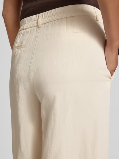 Frauenmodel trägt Culotte aus Viskose-Mix Modell 'Maiga flow' von OPUS in Creme mit Eingrifftaschen und Wide-Leg-Pants, Detailaufnahme Rückansicht.