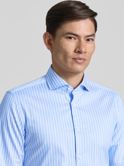 Männermodel trägt Slim Fit Businesshemd mit extra langem Arm Modell 'H-HANK' von BOSS, Optik: Allover-Muster, gestreift, Nahaufnahme Oberkörper. Passform: Slim Fit, Haifischkragen, durchgehende Knopfleiste, Label-Applikation, Ärmelform: extra lang, Sportmanschetten mit verstellbaren Knöpfen, Material: Baumwoll-Mix.
