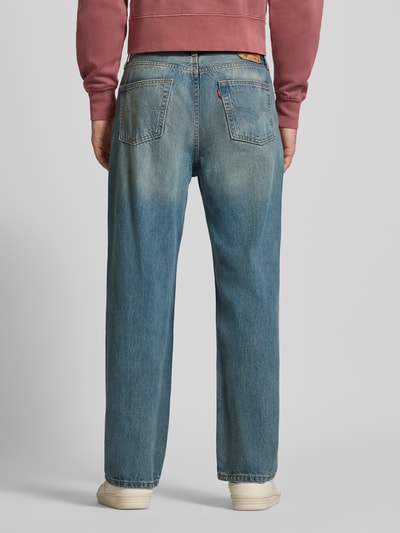 Männermodel trägt Straight Fit Jeans im 5-Pocket-Design Modell '565' von Levi's®, Reine Baumwolle, Loose-Fit, mittleres Blau, Ganzkörperansicht Rückansicht.