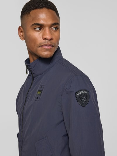 Männermodel trägt Jacke mit Pattentaschen Modell 'Alwin' von Blauer Usa in Dunkelblau, Label-Patches, Nahaufnahme Oberkörper, gerader Schnitt, Stehkragen