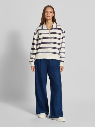 Modelka nosi szerokie jeansy Wide & Loose Fit Jeans aus Baumwoll-Lyocell-Mix od Marc O'Polo DENIM, ciemnoniebieski kolor, widok całej sylwetki z przodu.