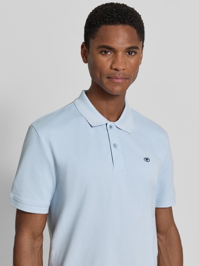 Männermodel trägt Regular Fit Poloshirt aus reiner Baumwolle von Tom Tailor in Hellblau, glatte Struktur, Nahaufnahme Oberkörper. Herren Poloshirt