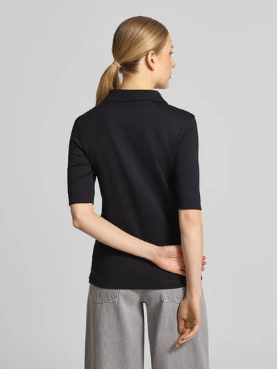 Kobiece model prezentuje Slim Fit Poloshirt mit Knopfleiste und 1/2-Arm von Christian Berg Woman z bawełny, czarny, długość tyłu w rozmiarze 36: 61 cm, krój slim fit, listwa guzikowa, rękaw o dł. 1/2, widok całej sylwetki z tyłu.
