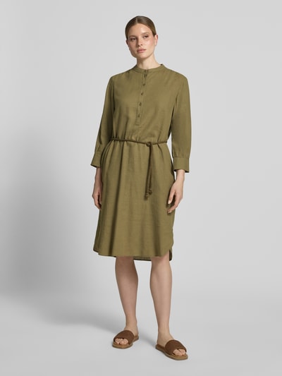 Frauenmodel trägt Midikleid aus Leinen-Mix mit Bindegürtel von Fynch-Hatton in Olivgrün, Knopfleiste, taillierter Schnitt, Mao-Kragen, Leinen-Viskose-Anteil, abgerundeter Saum, Ganzkörperansicht von vorne.