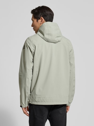 Männermodel trägt hellgraue Jacke mit Kapuze, gerader Passform und Napoleontasche, Jacke mit Napoleontasche Modell 'KOS' von Killtec, Ganzkörperansicht Rückansicht.