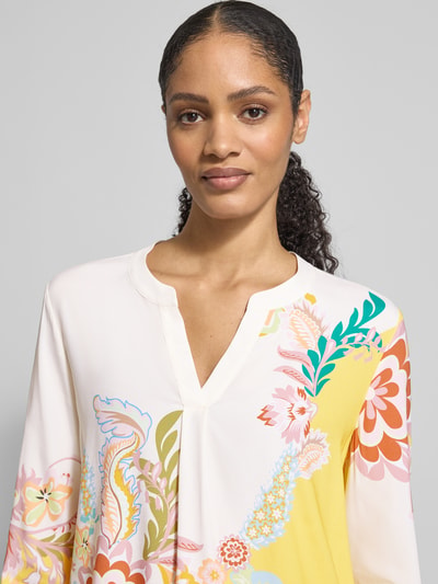 Vrouwenmodel draagt Regular Fit Bluse aus Seide-Elasthan-Mix mit Allover-Look van HERZENS, tuniekkraag, kleurrijk bloemendessin, zijde-elastaanmix, detailopname bovenlichaam.