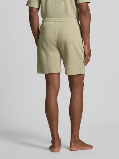 Männermodel trägt Regular Fit Sweatshorts aus Baumwoll-Mix von BOSS in hellem Beige, strukturierte Oberfläche, Ganzkörperansicht Rückansicht. Herren Sweatshorts von BOSS.