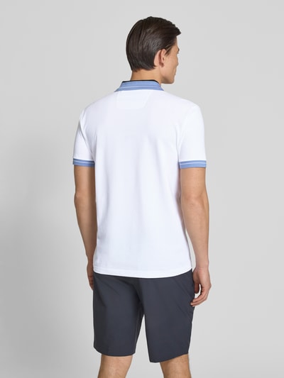 Männermodel trägt Regular Fit Poloshirt aus Baumwoll-Mix Modell 'PL_Member' von BOSS Green, weiß mit blauen Kontraststreifen, Piqué-Struktur, unifarben, kurzer Arm, Label-Schriftzug, Rückansicht Ganzkörperansicht.