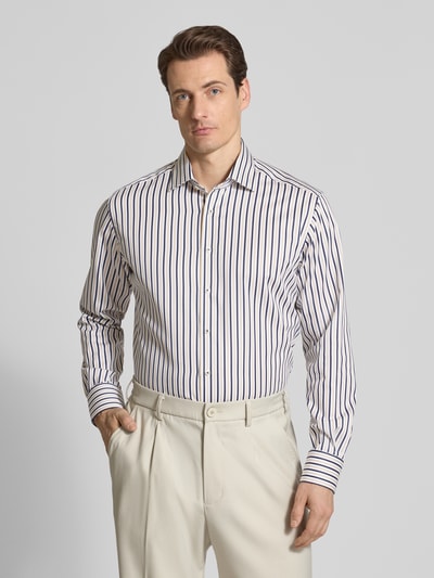 Męski model nosi Regular Fit Business-Hemd mit Kentkragen von ETERNA, bawełna, krój regular fit, kołnierzyk typu kent, listwa guzikowa, z długim rękawem, sportowe mankiety, długość tyłu w rozmiarze 40: 79 cm, szerokość ramion w rozmiarze 40: 46 cm, długość rękawów w rozmiarze 40: 64 cm, pionowe granatowe i białe pasy, gładka faktura, pełny widok z przodu