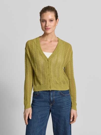 Frauenmodel trägt Strickjacke mit V-Ausschnitt Modell 'ROSI' von Mango in einem gelbgrünen Ton, Baumwoll-Mix, Knopfleiste, Regular Fit, Ganzkörperansicht von vorne.