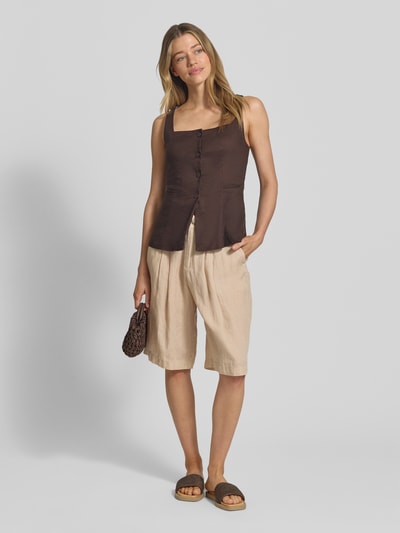 Frauenmodel trägt Wide Leg Leinenshorts mit Bundfalten von s.Oliver RED LABEL in Optik: Unifarben, Passform: Wide Leg, Bundfalten, Gürtelschlaufen, seitliche Eingrifftaschen, Gesäßtaschen, Material: Leinen; helle Naturfarbe, strukturierte Oberfläche, locker fallender Stoff; Ganzkörperansicht von vorne.