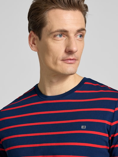 Männermodel trägt Regular Fit T-Shirt Mit Logo-Stitching von Christian Berg Men, blau mit roten Streifen, reine Baumwolle, Nahaufnahme Oberkörper.