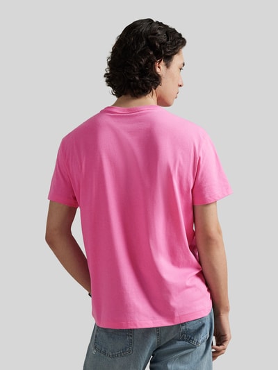 Männermodel trägt Regular Fit T-Shirt aus reiner Baumwolle von Polo Ralph Lauren in effen roze, jerseystructuur, rugaanzicht, unifarben, ralph lauren logo, ronde hals, korte mouw.
