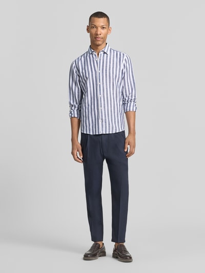 Männermodel trägt Slim Fit Business-Hemd mit Kentkragen Modell 'Pit' von JOOP! Collection, weiß-blau gestreift, Ganzkörperansicht von vorne, Baumwoll-Leinen-Mix, Knopfleiste, Sportmanschetten, abgerundeter Saum, Rückenlänge 74 cm, Schulterbreite 41 cm, Ärmellänge 67 cm, Größe 40.