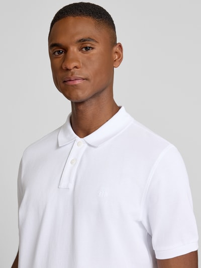 Männermodel trägt Poloshirt aus Baumwolle von MARC O’POLO DENIM in Weiß, Piqué mit Logo und Polokragen, Nahaufnahme Oberkörper.