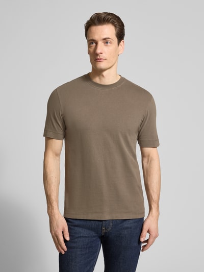 Männermodel trägt T-Shirt mit Rundhalsausschnitt von Drykorn in Beige, reine Baumwolle, Regular Fit, Ganzkörperansicht von vorne.