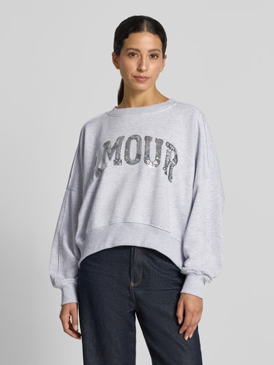 Frauenmodel trägt Oversized Sweatshirt mit Pailletten-Besatz Modell 'Amour' von miss goodlife aus Baumwolle, Ganzkörperansicht von vorne.