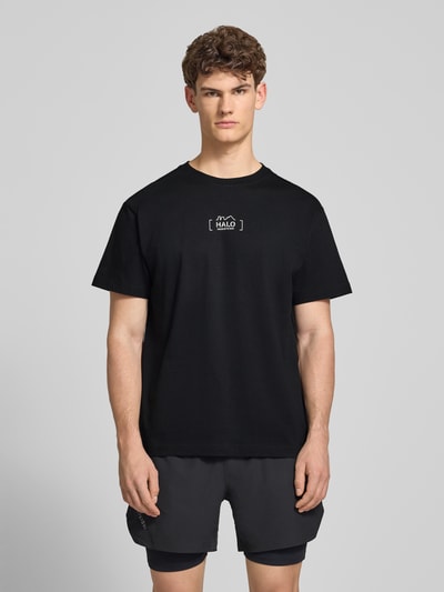 Männermodel trägt schwarzes T-Shirt mit Label-Print von HALO aus reiner Baumwolle, Regular Fit, Rundhalsausschnitt, Ganzkörperansicht von vorne