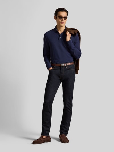 Männermodel trägt Regular Fit Poloshirt mit Logo-Stitching von Polo Ralph Lauren in Dunkelblau, kombiniert mit dunkler Jeans, Ganzkörperansicht von vorne, Herren Pullover von Polo Ralph Lauren.