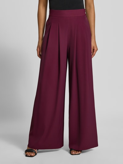 Frauenmodel trägt Wide Leg Stoffhose mit Reißverschlusstaschen von Rinascimento in Dunkelrot, Material-Mix mit Stretch, Ganzkörperansicht von vorne.