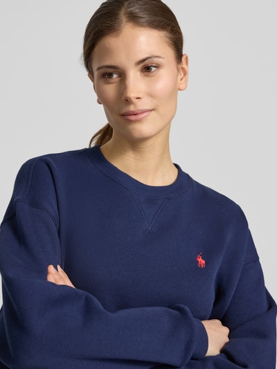 Vrouwenmodel draagt Oversized Sweatshirt aus Baumwoll-Mix van Polo Ralph Lauren, look: effen, pasvorm: oversized, logodetail, ronde hals, lange mouw, mouwboord en rompzoom geribd, materiaalverwerking: sweat, materiaal: katoenmix, nahaufnahme bovenlichaam.