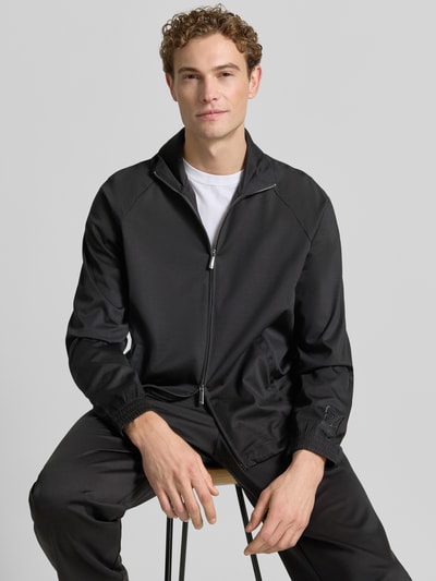 Männermodel trägt schwarze Sweatjacke mit Stehkragen und Zweiwege-Reißverschluss von Emporio Armani, Lyocell-Mix mit Viskose-Anteil, Eingrifftaschen, Regular-Fit, Rückenlänge 68 cm, Ärmellänge 84 cm, Ganzkörperansicht von vorne.