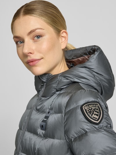 Frauenmodel trägt Daunenmantel mit wärmender Füllung Modell 'AGNES' von Blauer USA in Stepp-Optik, silbergraue Farbe, Nahaufnahme Oberkörper.