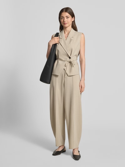 Frauenmodel trägt Barrel Fit Hose mit Längsnähten Modell 'Pija' von mbyM in Beige, Material-Mix mit Viskose, Ganzkörperansicht von vorne.