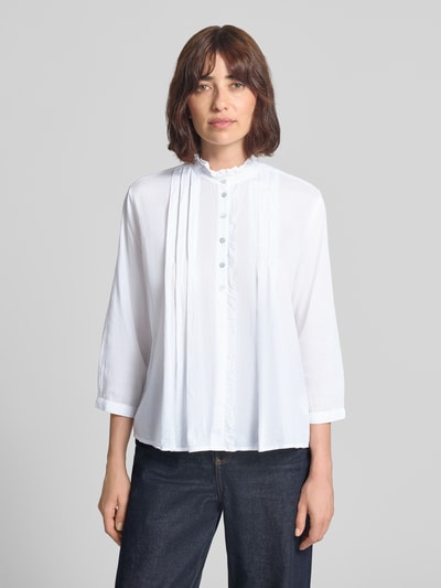 Vrouwenmodel draagt Regular Fit Bluse mit Rüschenbesatz van Christian Berg Woman, wit, puur katoen, opstaande kraag, 3/4-mouw, knoopsluiting, ruglengte maat 36: 53 cm, mouwlengte maat 36: 47 cm, voorkant, halve lichaamsopname.