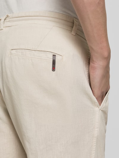 Mężczyzna nosi Hose aus Leinen-Baumwoll-Mix mit Tunnelzug von CINQUE, kolor beżowy, krój regular fit, model 'Juli', detal tylnej kieszeni, zbliżenie na górną część nogi, widok z tyłu.